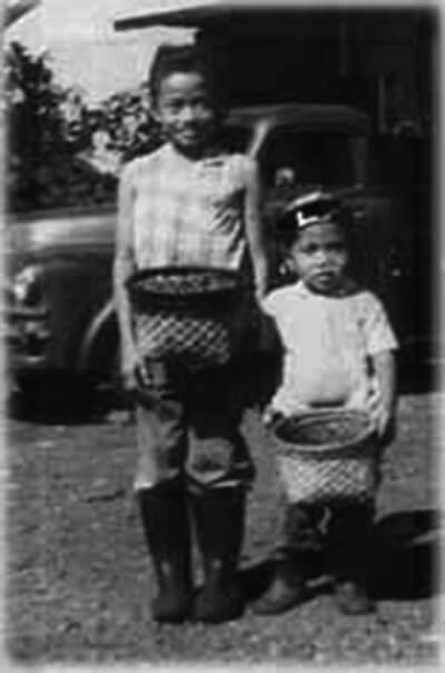 Children with child-sized versions of baskets used for picking coffee, ca. 1960s. (Photo courtesy Isabelo Sebastian.)