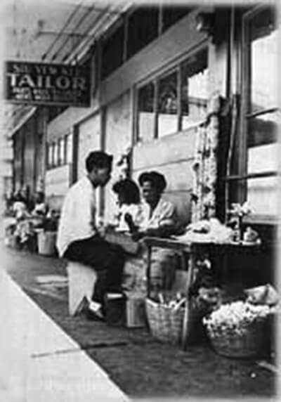 Interviewee Sophia Ventura with nephew at her Kekaulike Street lei stand in downtown Honolulu, ca. 1940. (Photo courtesy Charlotte Fuller.)